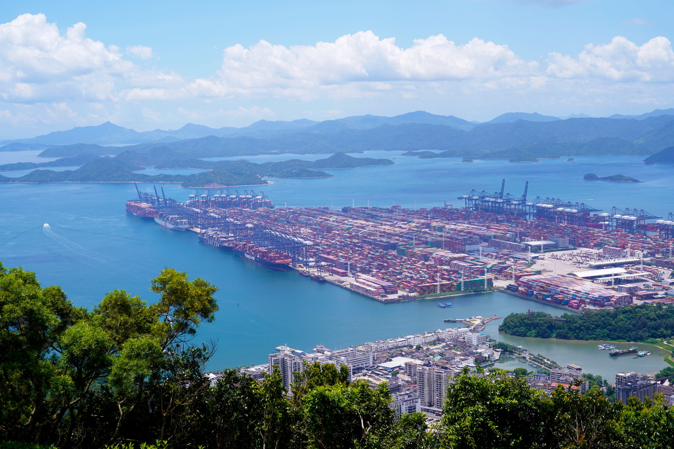 A sunny aerial view of an international cargo port on the coast